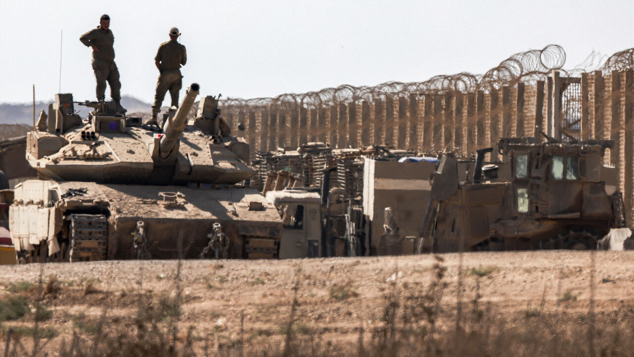 Israeli army soldiers stand atop the turret of a Merkava main battle tank positioned near armoured military bulldozers along the border with the Gaza Strip in southern Israel on Sept. 2, 2025. 