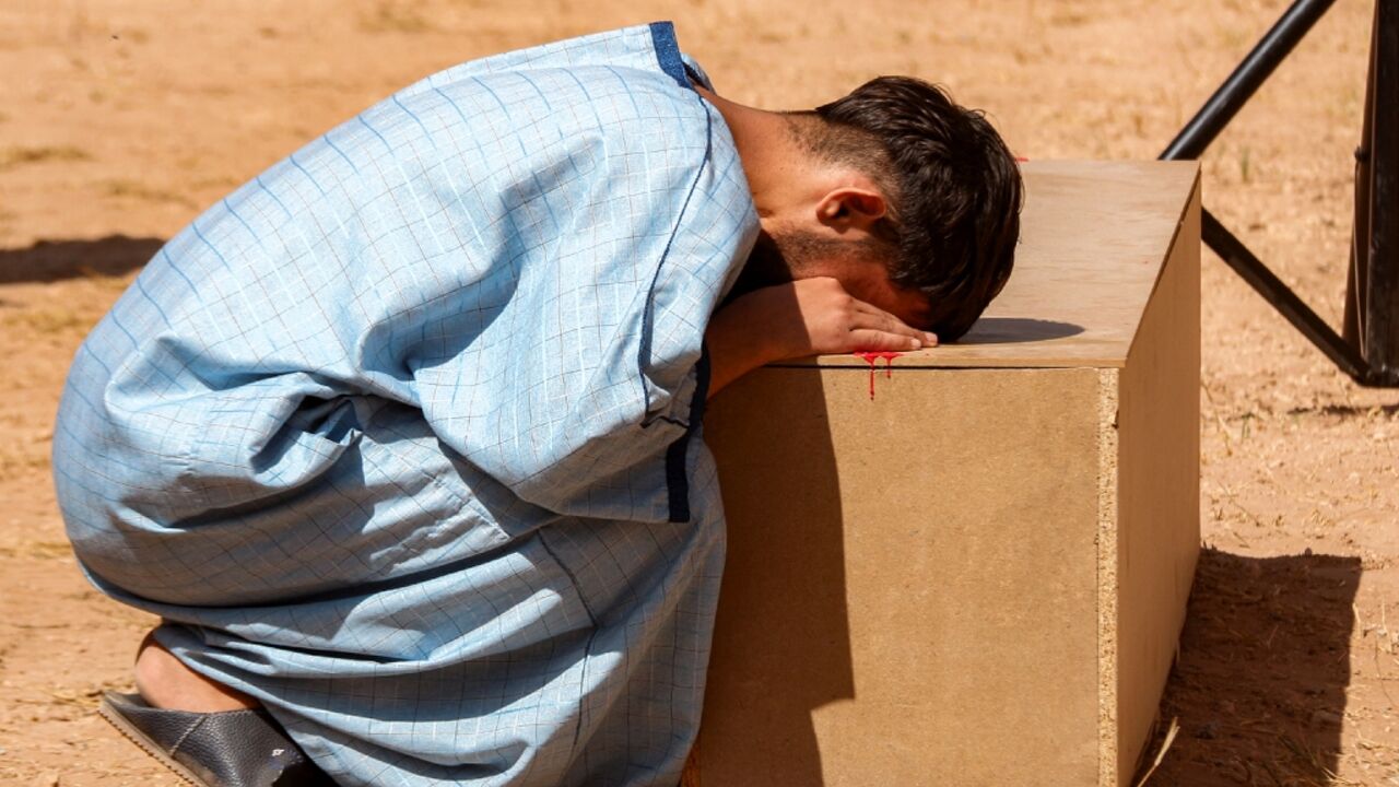 A mourner grieves by the casket of Abdessamad Oubella, a young man killed in the village of Lqliaa near Morocco's southern city of Agadir during protests called for by the GenZ 212 collective