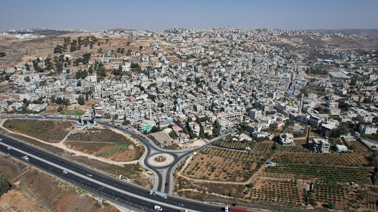 A drone view of Al-Arroub refugee camp alongside a new road, part of the expansion of Israeli bypass roads connecting Israeli settlers in the West Bank with Jerusalem, in the Israeli-occupied West Bank, September 29, 2025. REUTERS/Ammar Awad