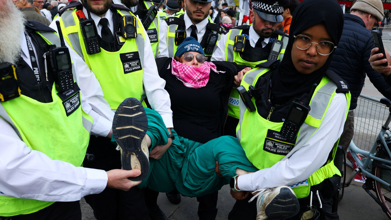 Police officers detain a protester during a mass demonstration organised by Defend our Juries, against the British government's ban on Palestine Action, at Trafalgar Square in London, Britain, October 4, 2025. REUTERS/Toby Melville