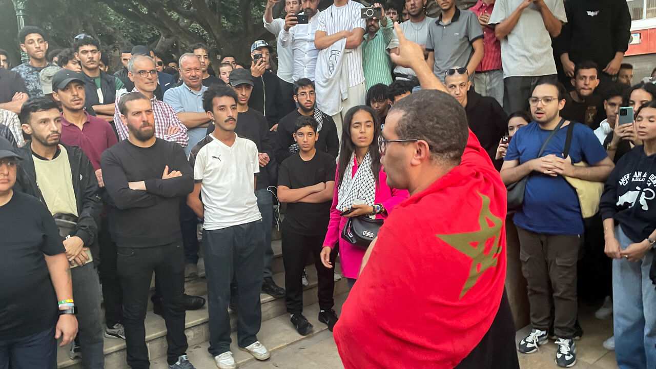 A man with a Moroccan flag draped over his shoulders gestures, as demonstrators attend a protest for social justice, near the parliament building, in Rabat, Morocco, October 3, 2025. REUTERS/Ahmed El Jechtimi