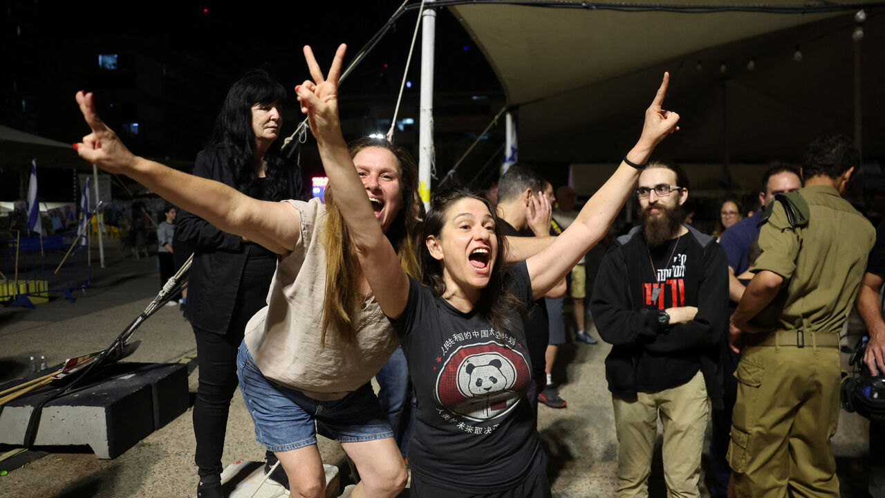 People celebrate, after U.S. President Donald Trump announced that Israel and Hamas agreed on the first phase of a Gaza ceasefire, at the "Hostages square", in Tel Aviv, Israel, October 9, 2025. REUTERS/Ronen Zvulun
