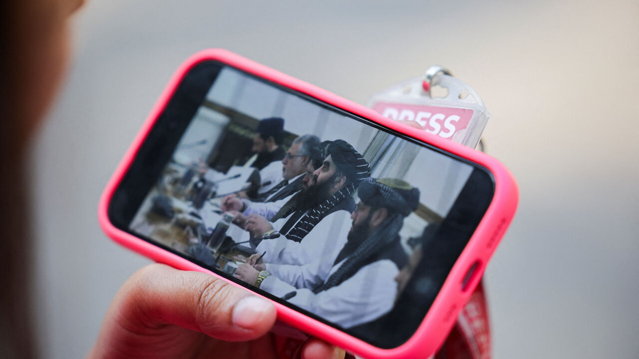 A journalist watches the live streaming of talks between Afghanistan's Foreign Minister Amir Khan Muttaqi and India's Foreign Minister S. Jaishankar, on her phone outside Hyderabad House in New Delhi, India, October 10, 2025. REUTERS/Anushree Fadnavis