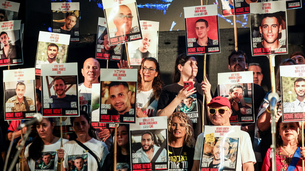 People hold placards with pictures of hostages who were kidnapped in the deadly October 7, 2023 attack by Hamas, after a ceasefire between Israel and Hamas in Gaza went into effect, at "Hostages square" in Tel Aviv, Israel, October 11, 2025. REUTERS/Ronen Zvulun