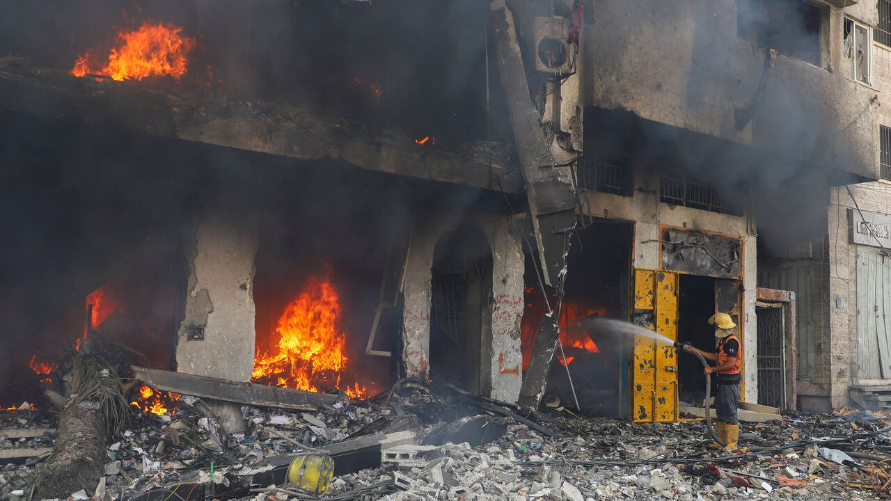 A Palestinian firefighter tries to extinguish fire at a residential building hit in an Israeli strike, amid an Israeli military operation, in Gaza City September 22, 2025. REUTERS/Ebrahim Hajjaj