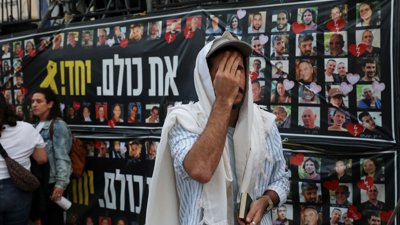 A man prays as people gather at "Hostages Square" to await the expected return of Israeli hostages, who have been held in Gaza since the deadly October 7, 2023 attack by Hamas, as part of a prisoner-hostage swap and a ceasefire deal between Israel and Hamas, in Tel Aviv, Israel, October 13, 2025. REUTERS/Ronen Zvulun