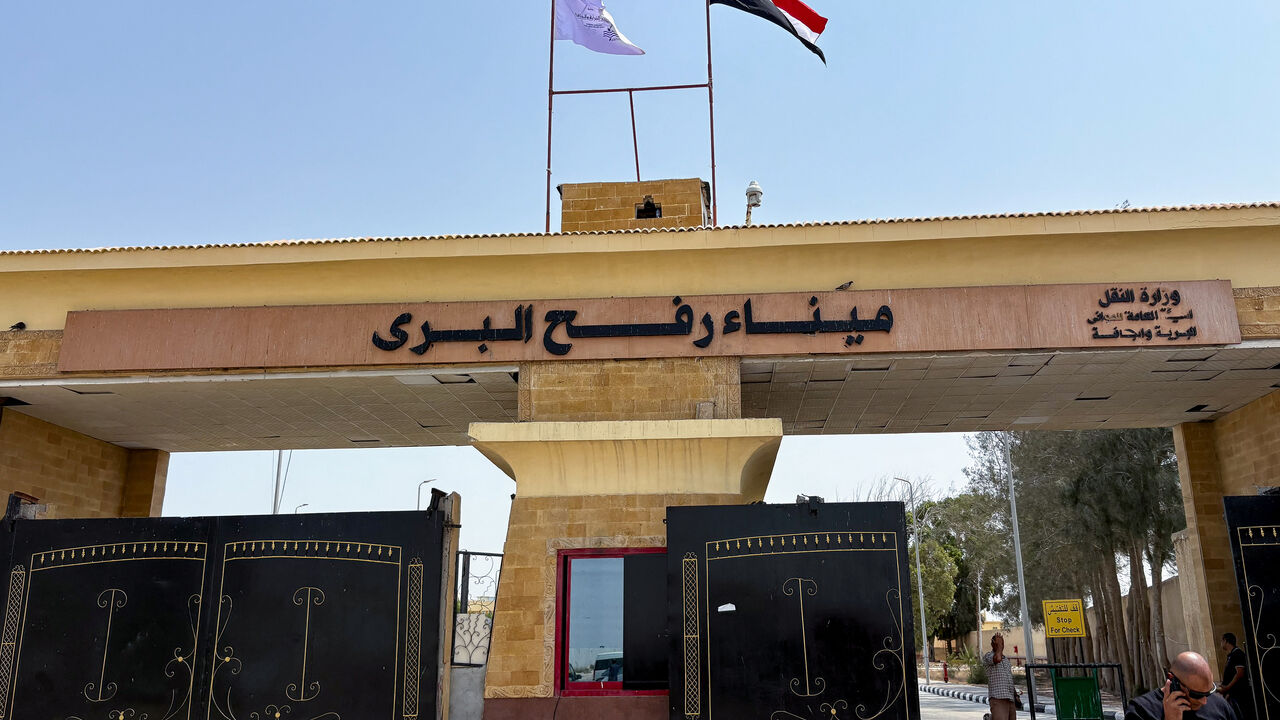 People stand at the Rafah border crossing between Egypt and the Gaza Strip, in Rafah, Egypt, August 11, 2025. REUTERS/Alexander Dziadosz