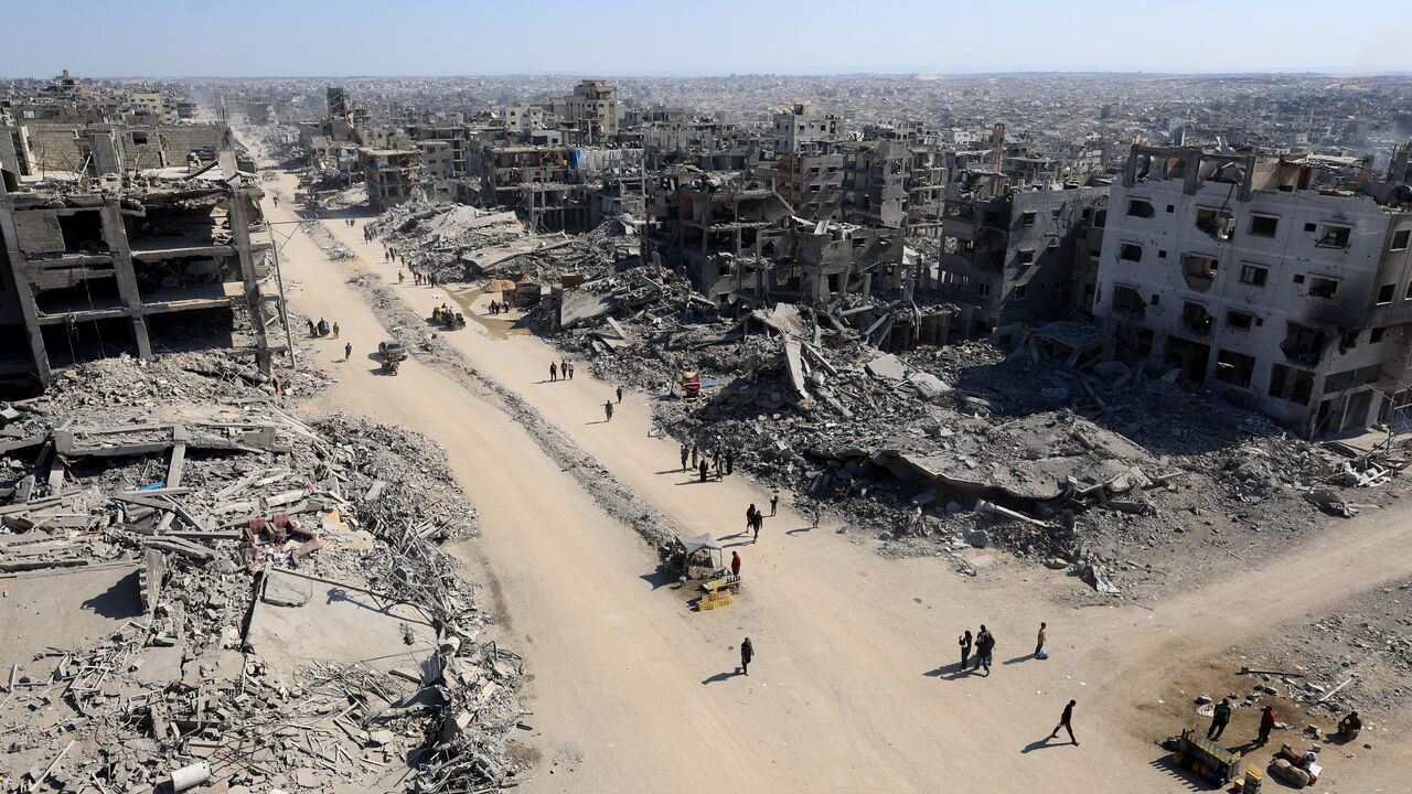 Palestinians walk past the rubble of destroyed buildings, amid a ceasefire between Israel and Hamas, in Gaza City, October 16, 2025. REUTERS/Dawoud Abu Alkas     TPX IMAGES OF THE DAY