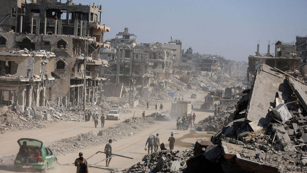 FILE PHOTO: Palestinians walk past the rubble of destroyed buildings, amid a ceasefire between Israel and Hamas, in Gaza City, October 16, 2025. REUTERS/Dawoud Abu Alkas/File Photo