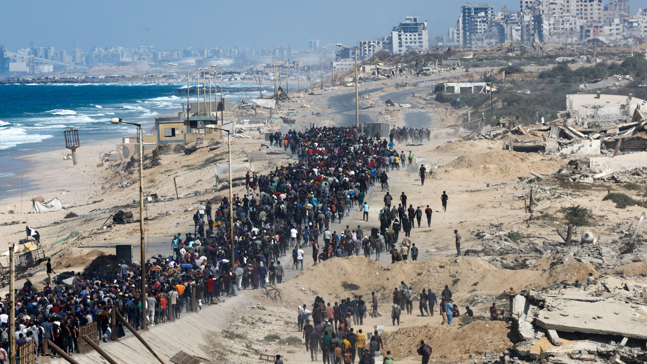 Palestinians, who were displaced to the southern part of Gaza at Israel's order during the war, walk along a road as they attempt to return to the north after a ceasefire, in the central Gaza Strip, October 10. REUTERS/Mahmoud Issa