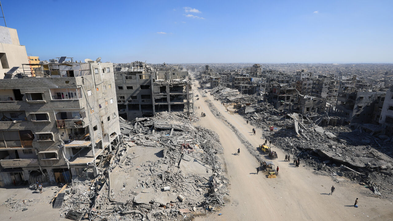Palestinians walk past the rubble of destroyed buildings, amid a ceasefire between Israel and Hamas, in Gaza City, October 16, 2025. REUTERS/Dawoud Abu Alkas