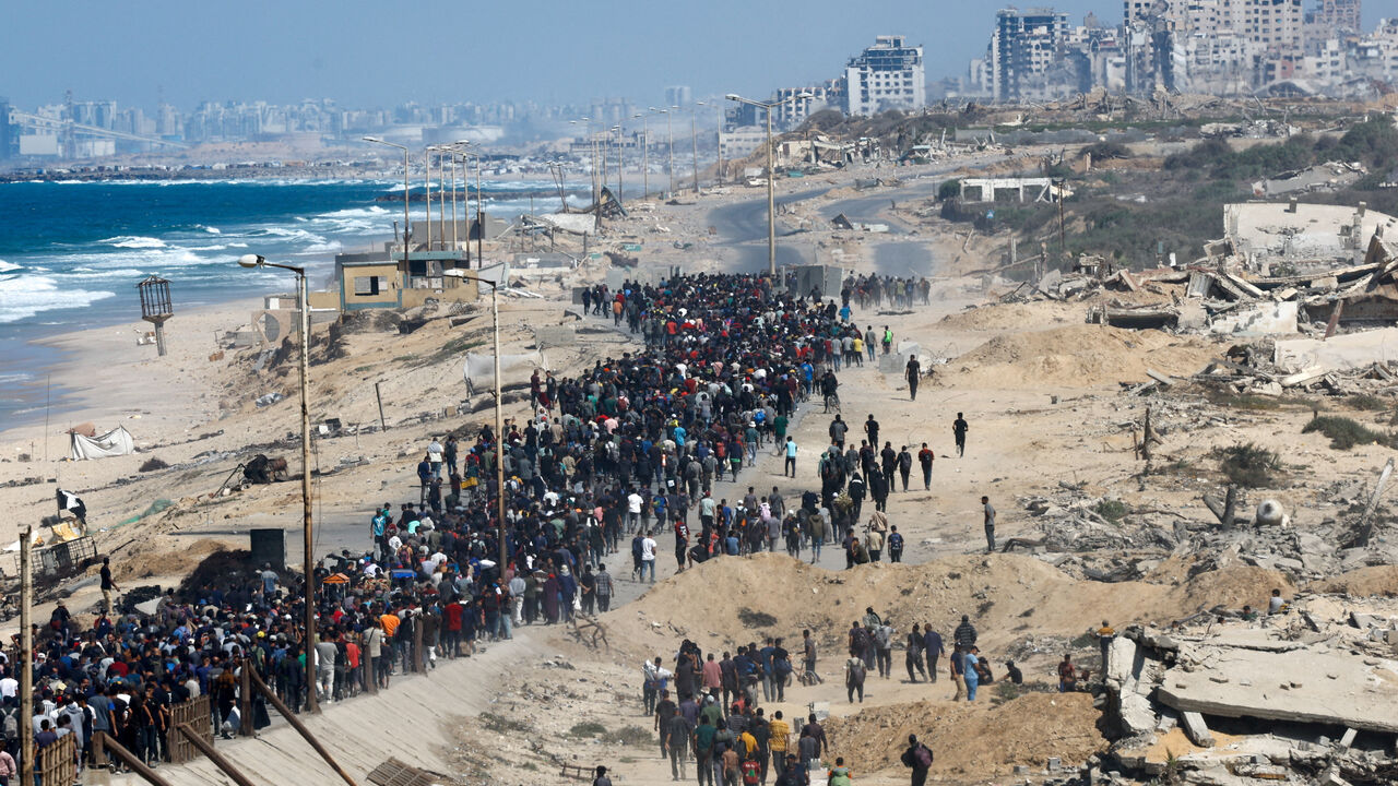 Palestinians, who were displaced to the southern part of Gaza at Israel's order during the war, walk along a road as they attempt to return to the north after a ceasefire, in the central Gaza Strip, October 10. REUTERS/Mahmoud Issa