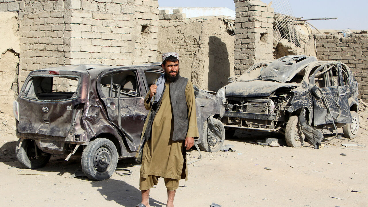 A Taliban fighter stands next to vehicles destroyed during an airstrike, following a temporary ceasefire, amid the conflict between Afghanistan and Pakistan, in Spin Boldak district of Kandahar Province, Afghanistan, October 16, 2025. REUTERS/Stringer