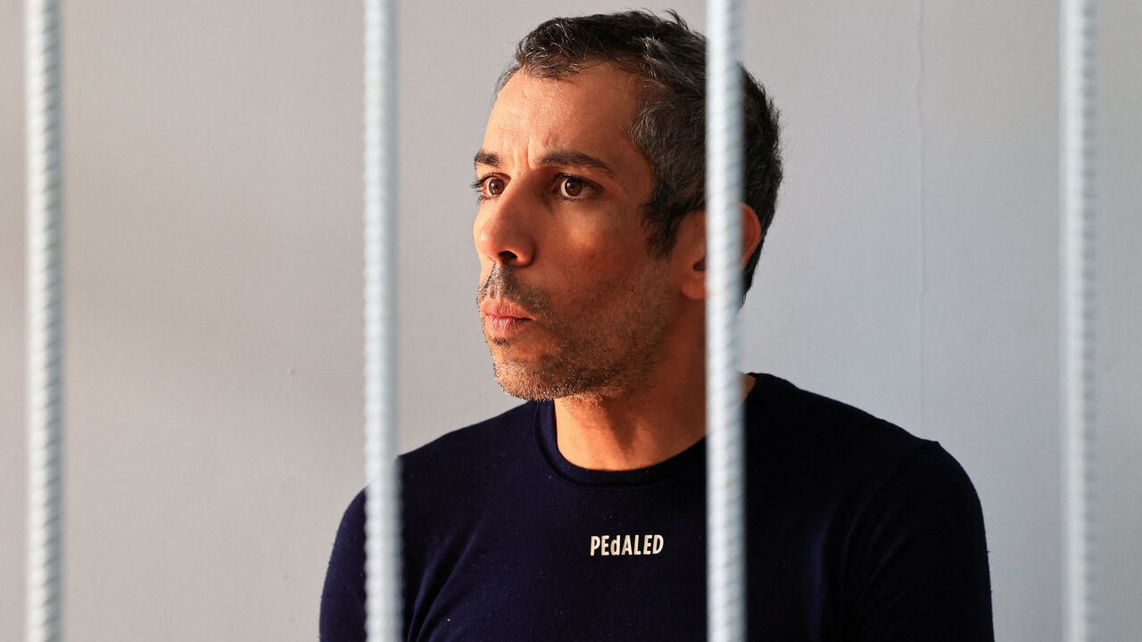 French cyclist Sofiane Sehili, who was reportedly arrested after twice attempting to cross the Russian border from China while trying to break the world record for the fastest cycle crossing of the Eurasian landmass, from Lisbon to Vladivostok, reacts inside an enclosure for defendants before a court hearing in the far eastern settlement of Pogranichniy, Russia, October 23, 2025. REUTERS/Tatiana Meel