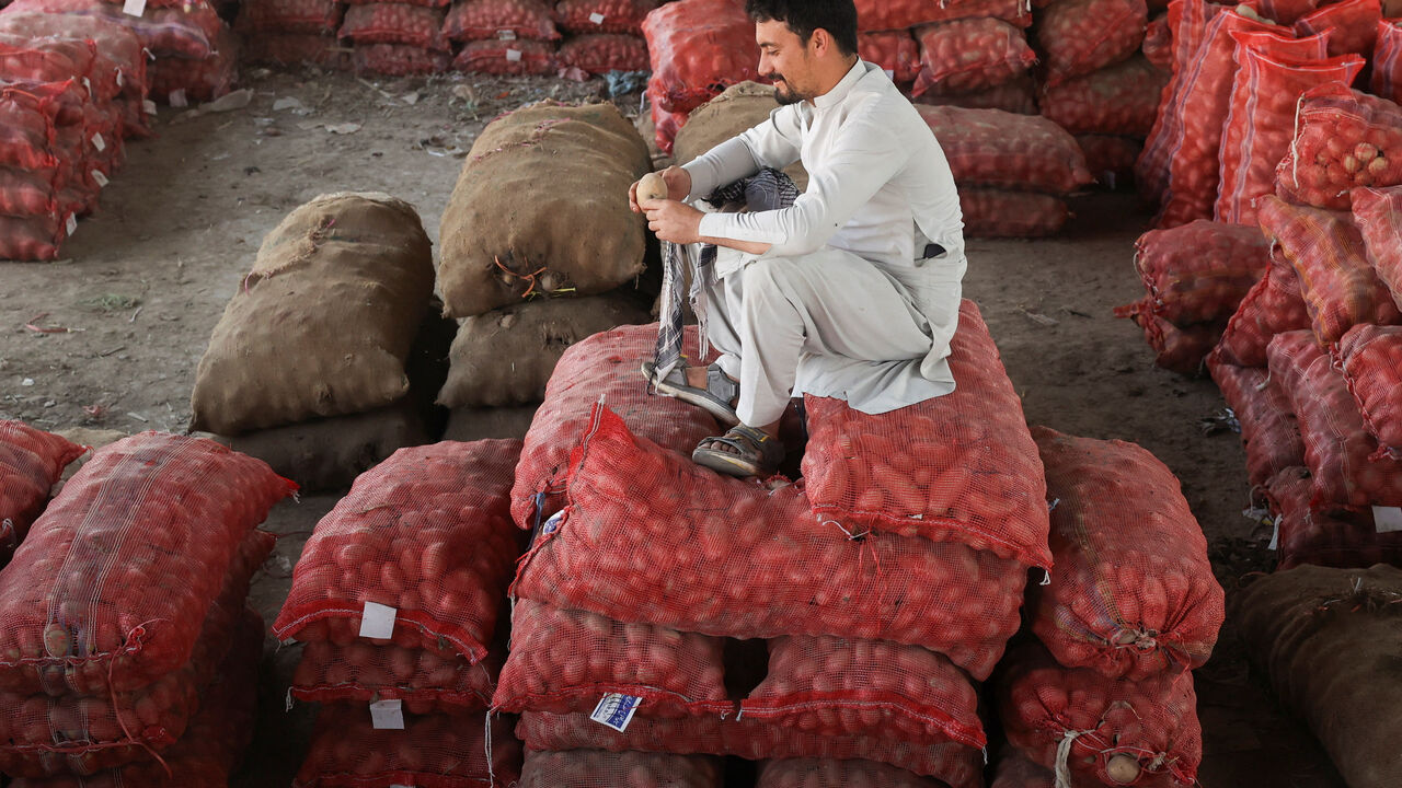 A man sits on sacks of potatoes at a wholesale vegetable market, as prices of various vegetables and fruits rose after Pakistan closed border crossings with Afghanistan following exchanges of fire, and a ceasefire deal was later agreed upon by the two nations, in Peshawar, Pakistan, October 23, 2025. REUTERS/Fayaz Aziz