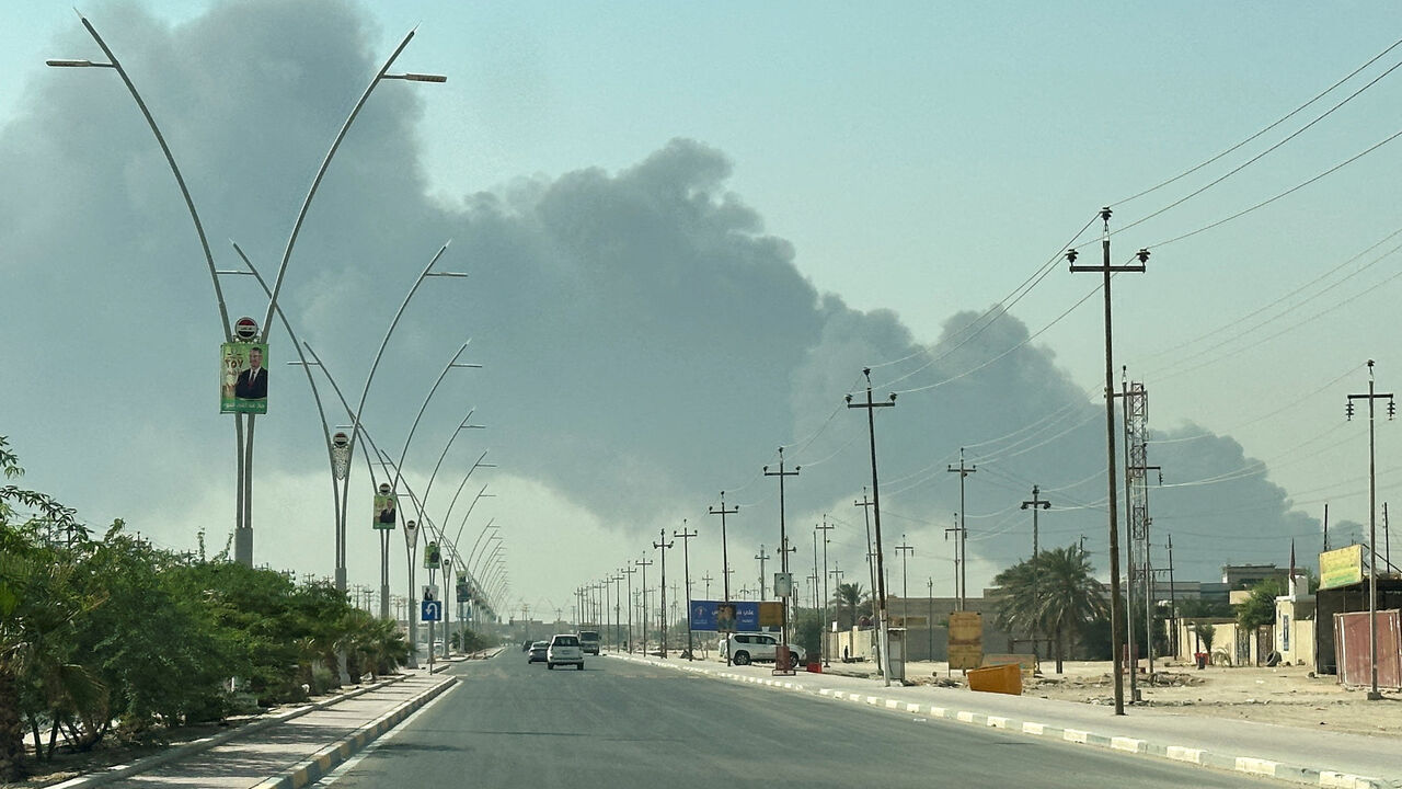 Smoke rises from a fire at an oil pipeline in Iraq's Zubair oilfield, as seen through a car window, near Basra, Iraq October 26, 2025. REUTERS/Mohammed Aty