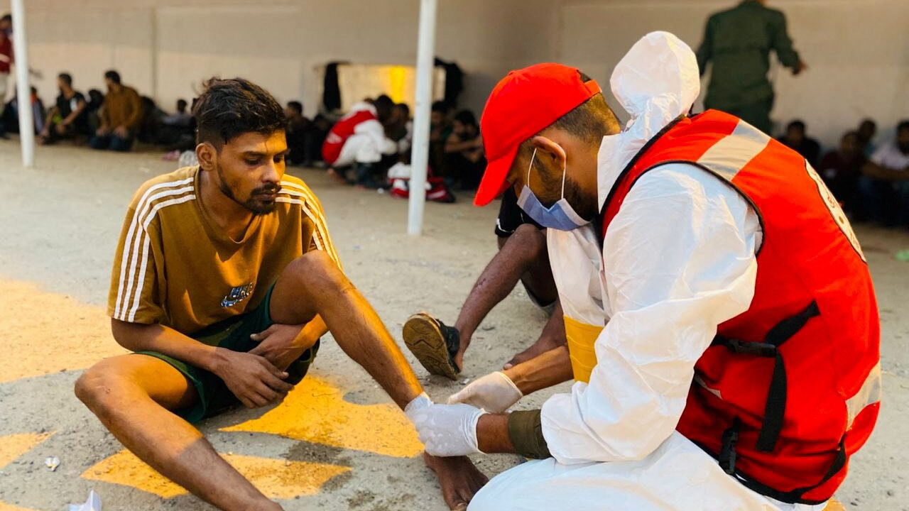 A member of the Red Crescent provides medical aid to a man in a location given as near Surman, Libya, after a migrant boat capsized west of Libya's capital Tripoli, in this handout image released on October 28, 2025. Libyan Red Crescent Society in Sabratha/Handout via REUTERS
