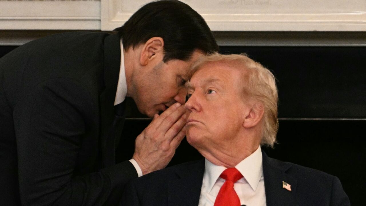US Secretary of State Marco Rubio whispers in the ear of President Donald Trump 
