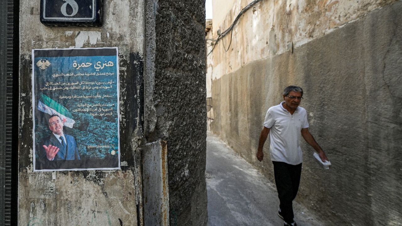 An election poster of Henry Hamra, a Jewish Syrian-American parliamentary candidate, is displayed on the entrance of the closed Jewish Maimonides School of Damascus
