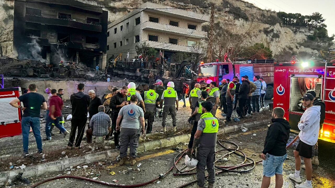Rescuers and first responders stand outside a damaged building following an overnight Israeli strike in Al-Msayleh area in southern Lebanon