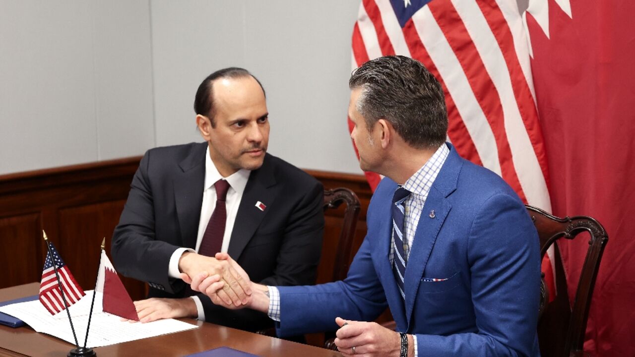US Defense Secretary Pete Hegseth (R) and Qatari Defense Minister Sheikh Saoud bin Abdulrahman Al Thani shake hands after signing a deal to establish a Qatari Emiri Air Force training facility at the Mountain Home Air Force Base in Idaho