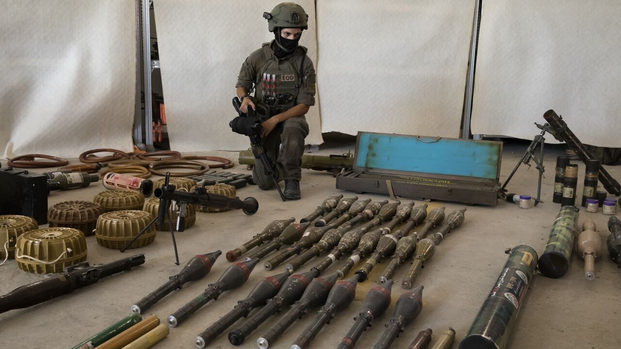 An Israeli soldier displays military equipment and ammunition that Hamas and Palestinan militants used at the time of the attack on the Israeli south border with the Gaza Strip on Oct. 20, 2023, in Kiryat Malakhi, Israel.