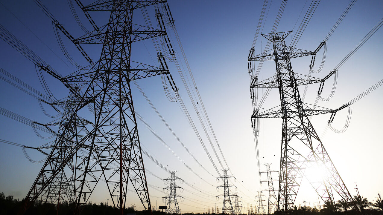 The sun sets behind overhead power lines as the Kuwaiti Ministry of Electricity requested citizens to ration their electricity usage at peak times due to outages caused by the increased pressure on power stations amid soaring temperatures and heightened energy demand, Kuwait City, Kuwait, June 19, 2024.