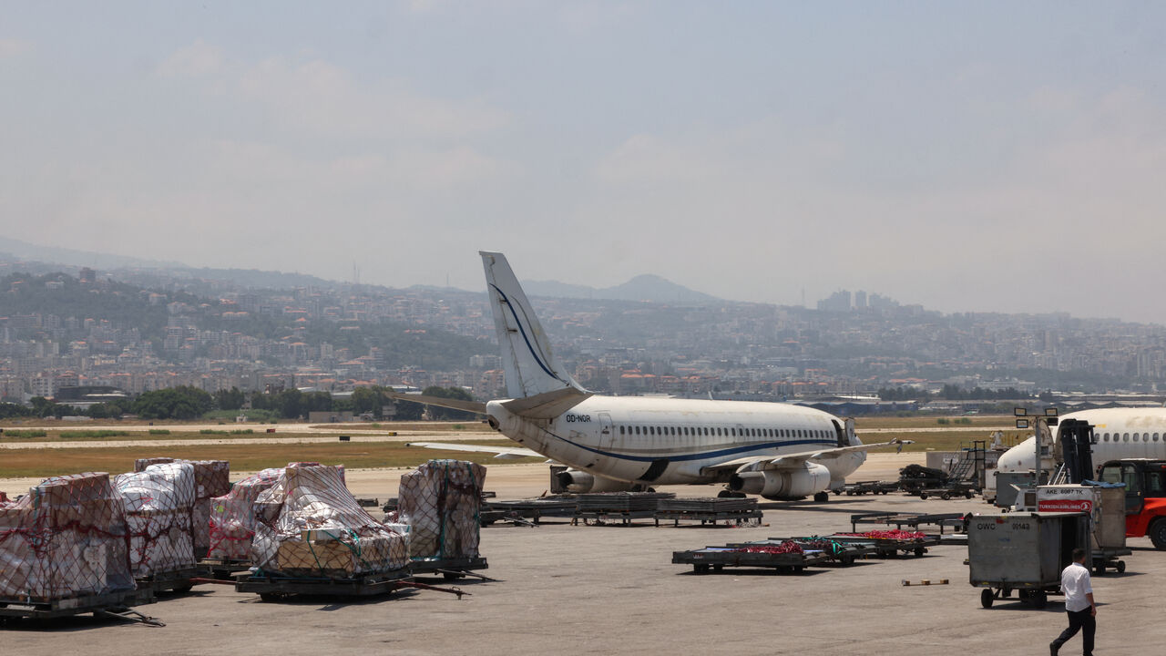 A photo taken during a tour organized by the Lebanese Ministry of Public Works and Transport shows staff loading cargo onto a plane at Beirut's international airport on June 24, 2024. 
