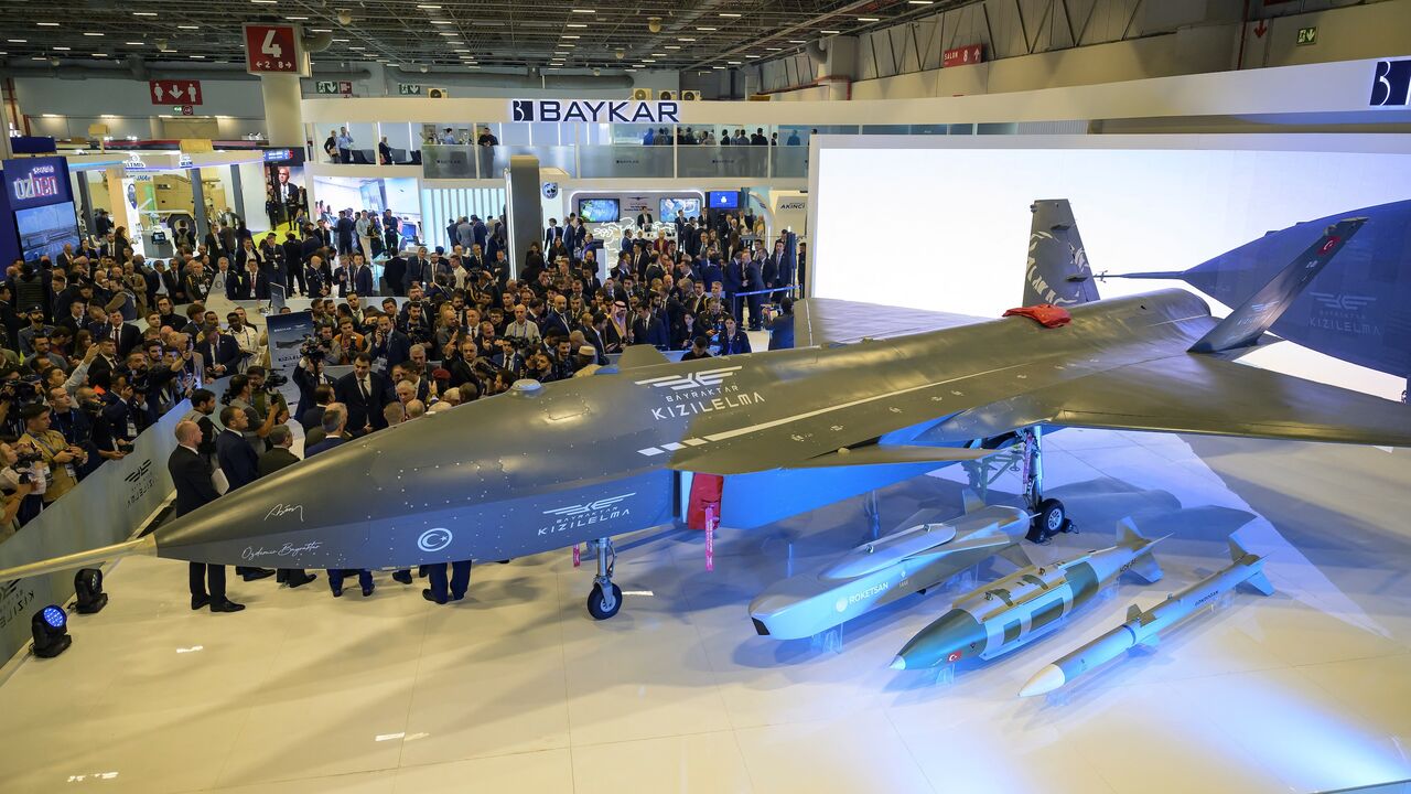 Visitors stand looking at the Bayraktar Kizilelma UCAV at the International Defence and Aerospace exhibition in Istanbul on Oct. 22, 2024.