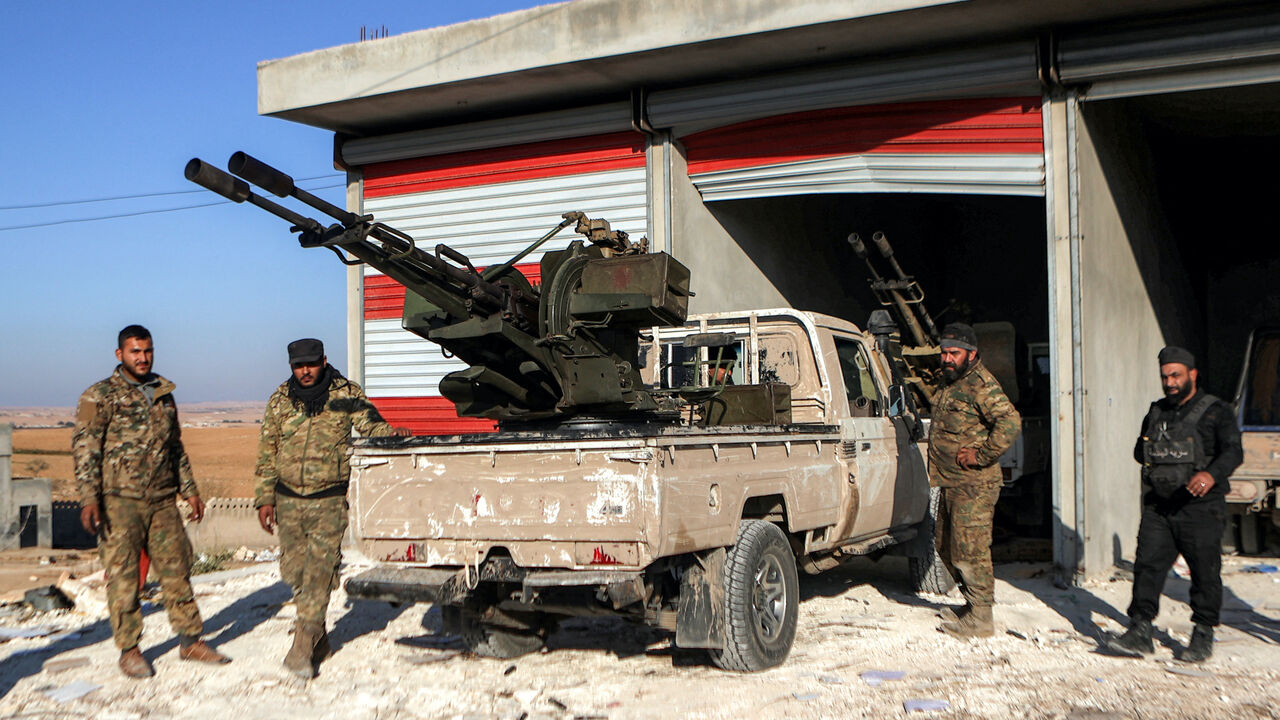 Fighters from the Turkish-backed Syrian National Army faction stand by a "technical" pickup truck at a position near the Tishrin Dam in the vicinity of Manbij, in the east of Syria's northern Aleppo province, on January 10, 2025 amidst ongoing battles with the Kurdish-led Syrian Democratic Forces (SDF).