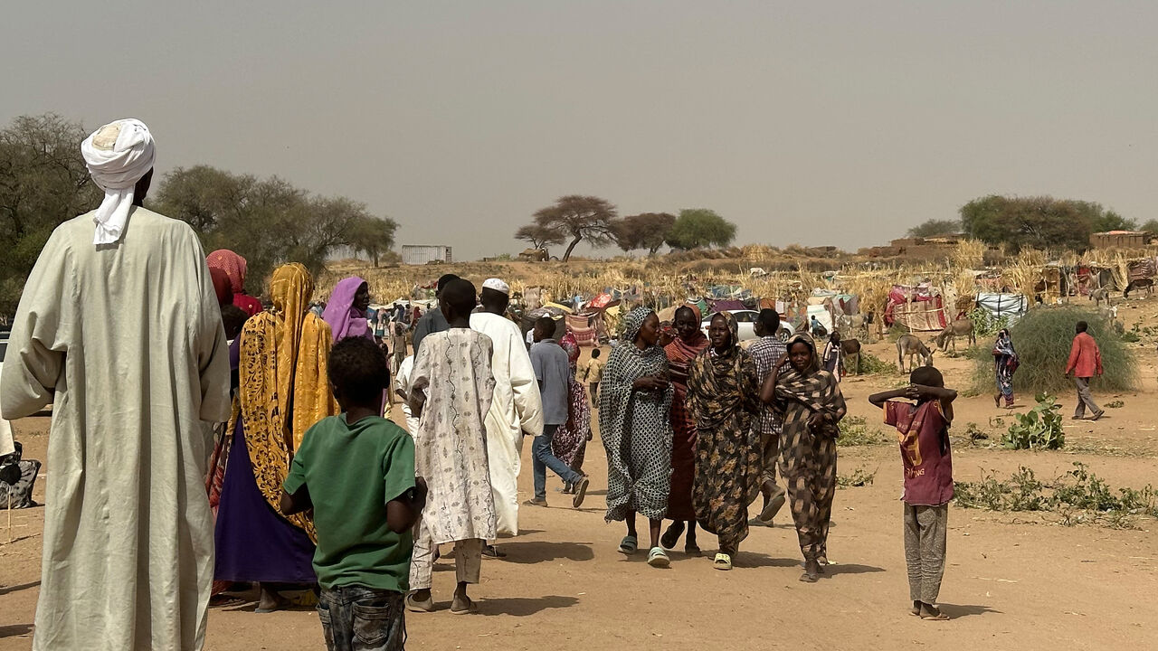 People who fled the Zamzam camp for the internally displaced after it fell under RSF control walk in a makeshift encampment in an open field near the town of Tawila in war-torn Sudan's western Darfur region on April 13, 2025. 
