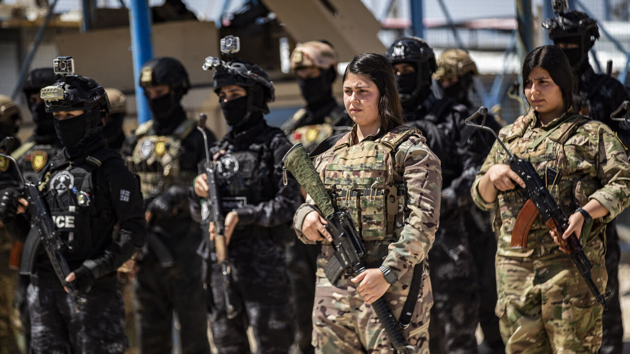 Members of the Syrian Kurdish Asayish security forces stand guard at the Kurdish-run al-Hol camp, which holds relatives of suspected Islamic State (IS) group fighters in the northeastern Hasakeh governorate, on April 18, 2025, as the Syrian Democratic Forces mount a security campaign against IS "sleeper cells" in the camp. 