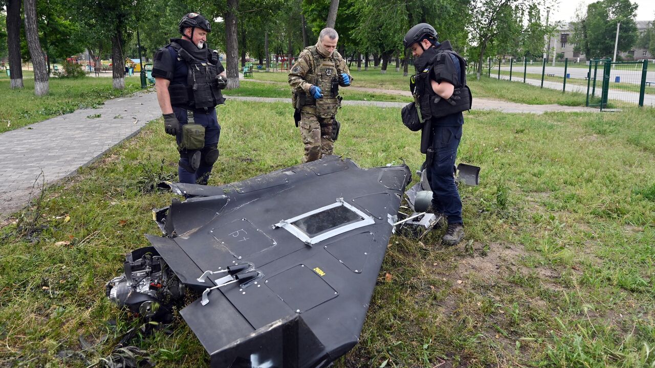 Ukrainian explosives experts and police officers examine parts of a Shahed-136 military drone following an air attack in Kharkiv on June 4, 2025, amid the Russian invasion of Ukraine. 