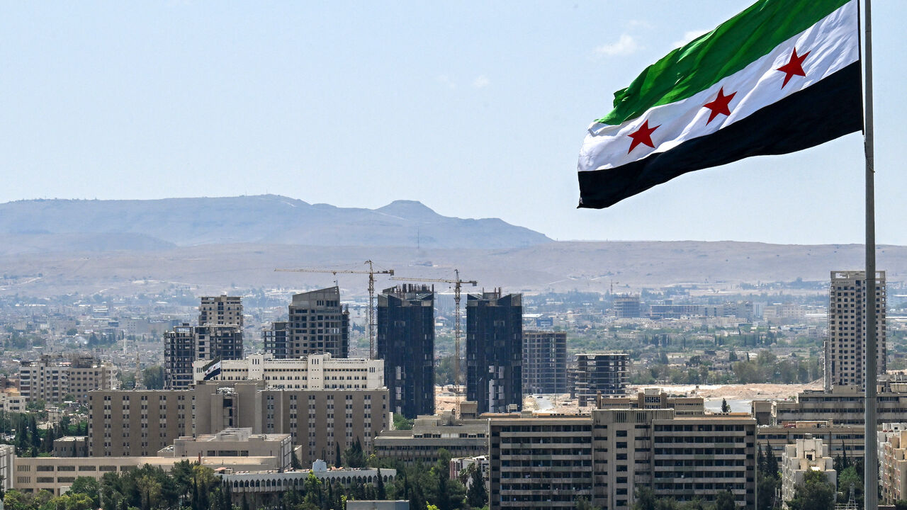 A large Syrian flag flutters above Tishreen Park in Damascus on June 4, 2025.