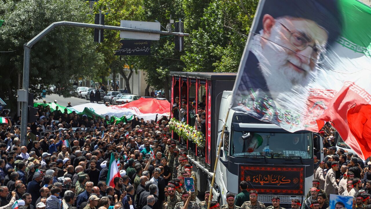 In this picture obtained from Iran's ISNA news agency, a flag with the portrait of Iran's supreme leader, Ayatollah Ali Khamenei, is waved during the funeral procession of 15 people killed in Israeli strikes during the 12-day war between Israel and Iran, in the city of Mashhad on June 27, 2025. 