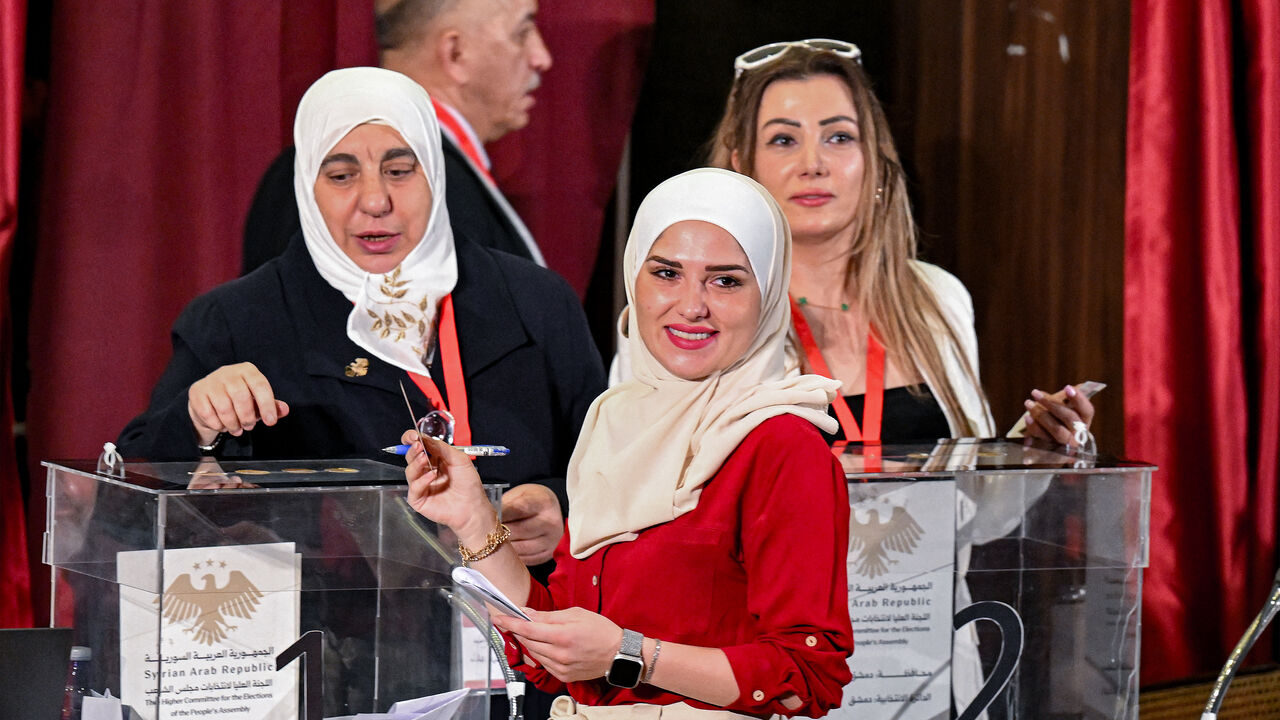 A member of Syria's local committees votes in the country's selection process to designate an interim parliament, in Damascus on Oct. 5, 2025. 