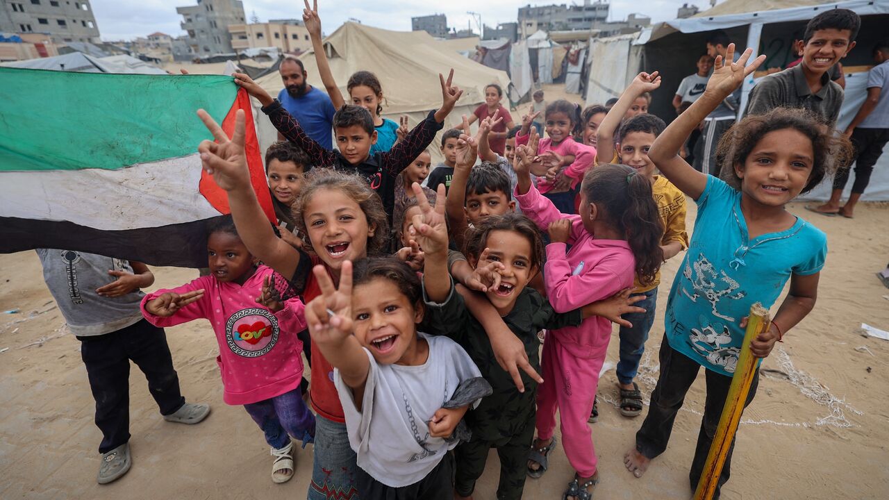 Palestinian children celebrate at a camp for displaced people in Nuseirat in the central Gaza Strip on Oct. 9, 2025, following news of a new Gaza ceasefire deal.