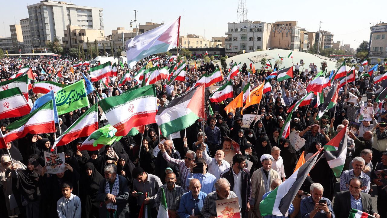Protesters wave Iranian and Palestinian flags in solidarity with the Palestinian people in Gaza during a demonstration in Tehran on Oct. 10, 2025.