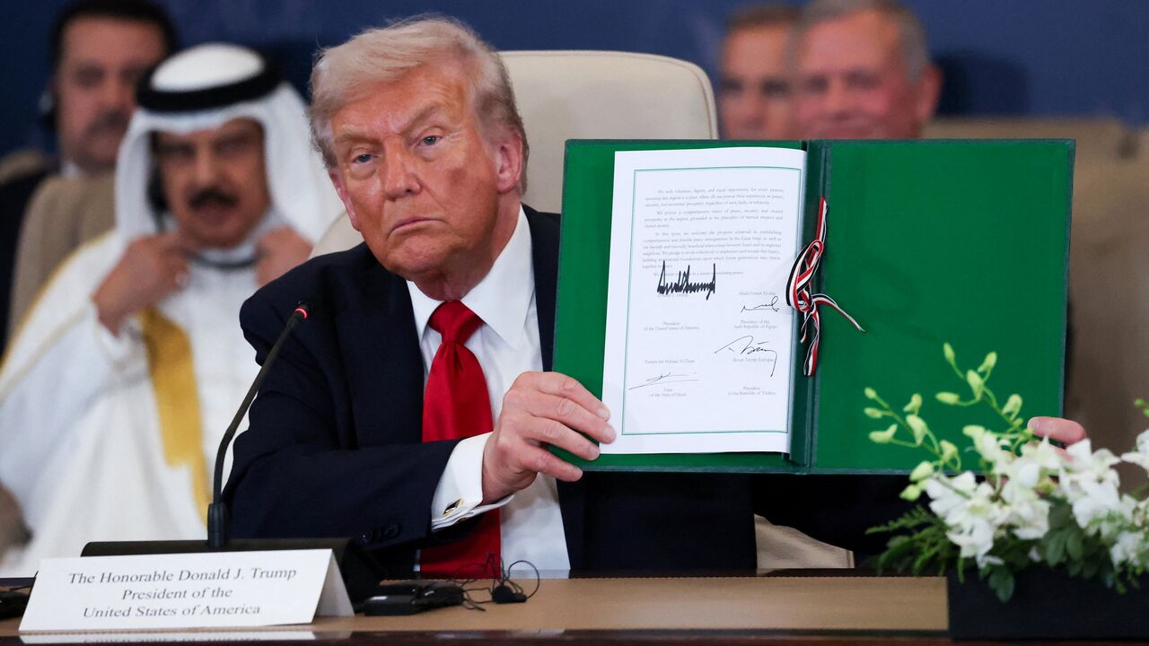 President Donald Trump poses with the signed agreement at a world leaders' summit on ending the Gaza war on Oct. 13, 2025, in Sharm el-Sheikh, Egypt. 