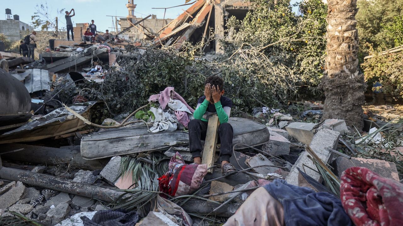 A boy reacts sitting amid the rubble of a house destroyed in an Israeli strike in Nuseirat, in the central Gaza Strip, on Oct. 29, 2025. 