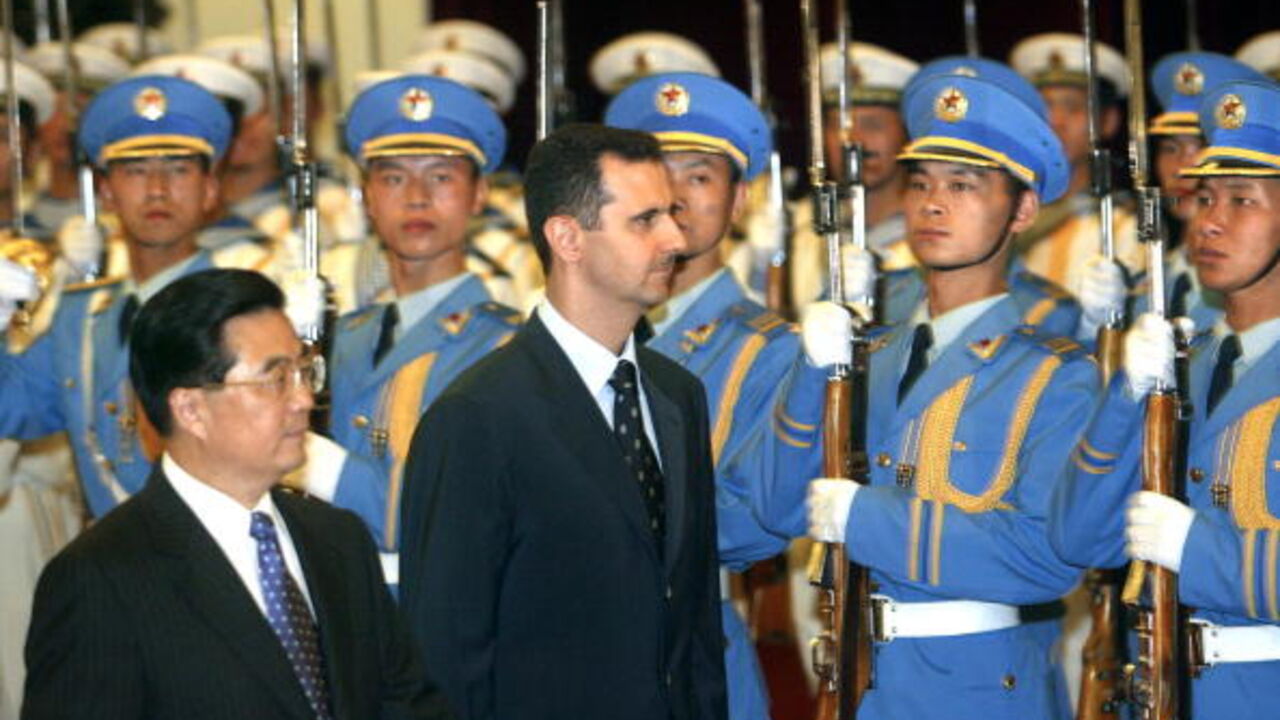 BEIJING, CHINA: Visiting Syrian President Bashar al-Assad (R) walks with Chinese President Hu Jintao (R), 22 June 2004, during a welcoming ceremony at the Great Hall of the People in Beijing. The visit is the first by a Syrian head of state to China since the two countries established relations in 1956. AFP PHOTO/POOL/Frederic J. BROWN (Photo credit should read FREDERIC J. BROWN/AFP via Getty Images)