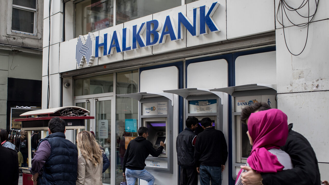 People walk past a branch of Turkish bank HalkBank on Dec. 1, 2017 in Istanbul, Turkey.