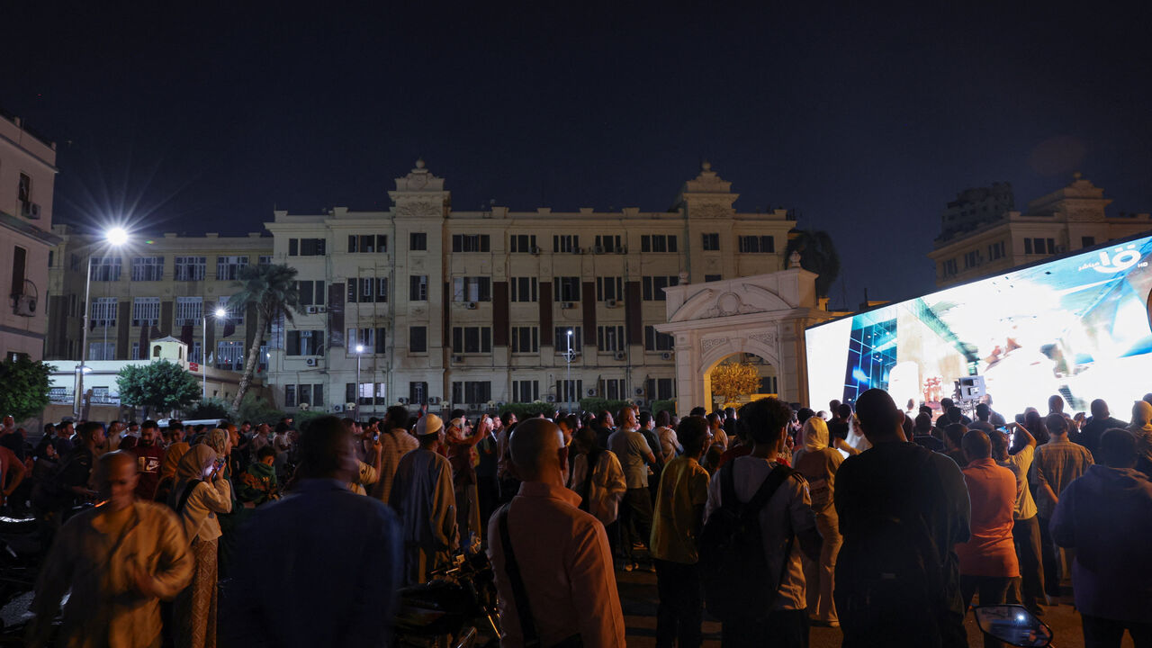 People gather to watch the official opening ceremony of the Grand Egyptian Museum (GEM) on a big screen in the downtown area near Tahrir Square, in front of Abdeen Palace Museum, in Cairo, Egypt, November 1, 2025. REUTERS/Amr Abdallah Dalsh