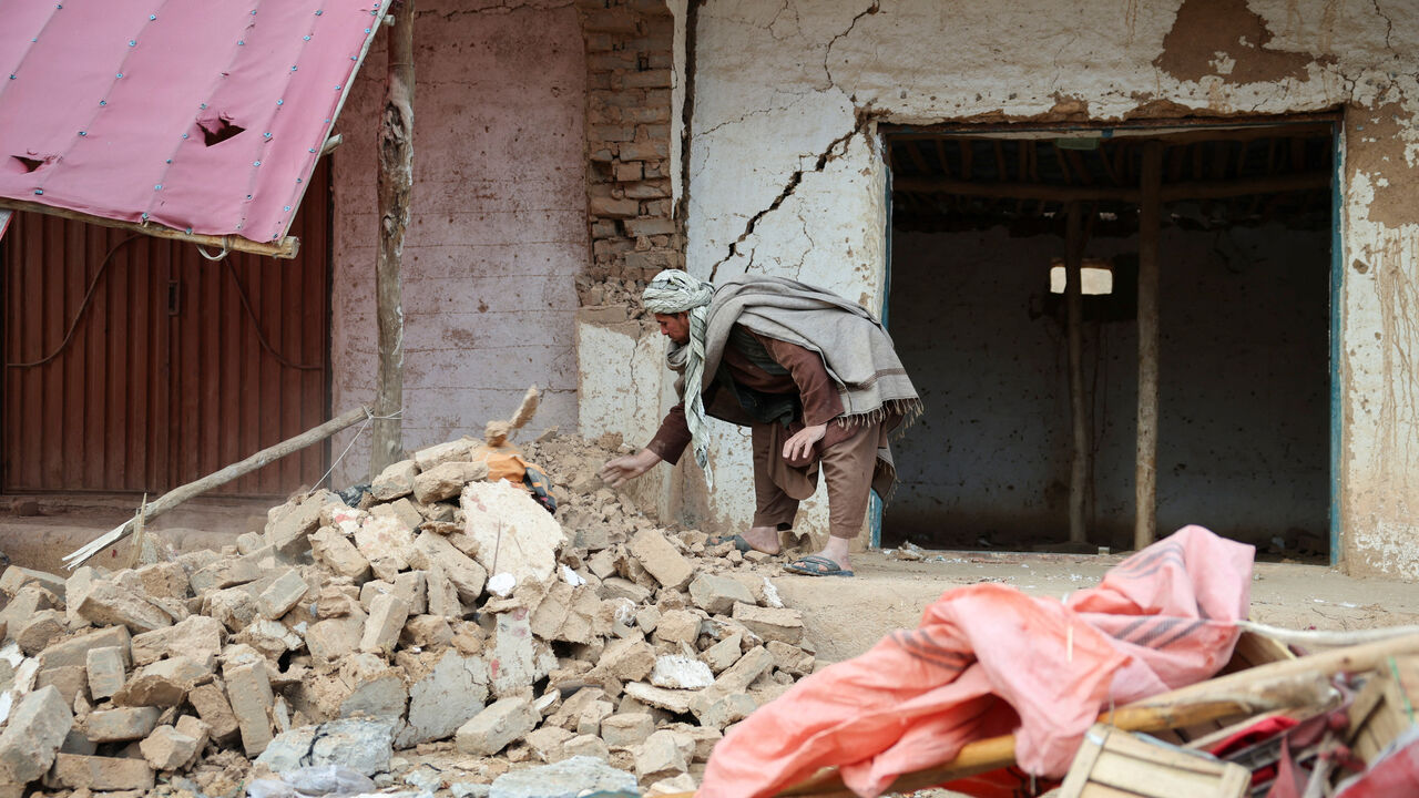 A man remove debris next to damaged shops, in the aftermath of an earthquake, in Samangan province, Afghanistan, November 4, 2025. REUTERS/Sayed Hassib