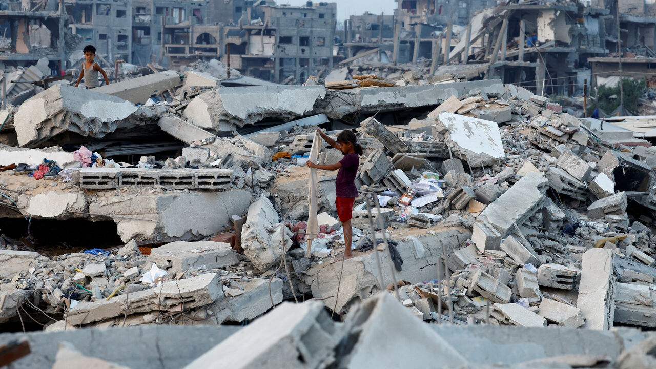 Palestinian children stand on the rubble of destroyed buildings, amid a ceasefire between Israel and Hamas, in Jabalia, northern Gaza Strip, November 6, 2025. REUTERS/Mahmoud Issa
