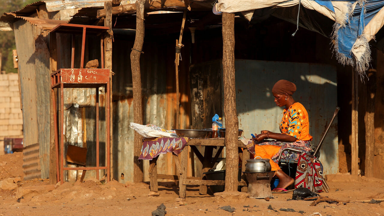 A woman prepares food on the road side, amid ongoing fuel shortages caused by a blockade imposed by al Qaeda-linked insurgents in early September, in Bamako, Mali, October 31, 2025. REUTERS/Stringer