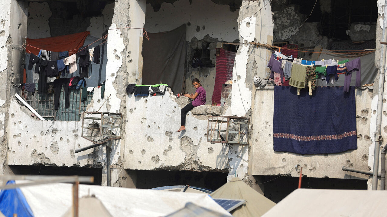 A displaced Palestinian girl sits on a wall of a damaged school where she has taken shelter in Gaza City, November 11. REUTERS/Dawoud Abu Alkas