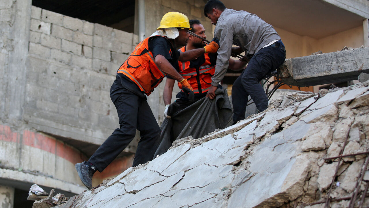 Palestinians inspect the site of an Israeli strike, in Gaza City, November 22, 2025. REUTERS/Mahmoud Issa