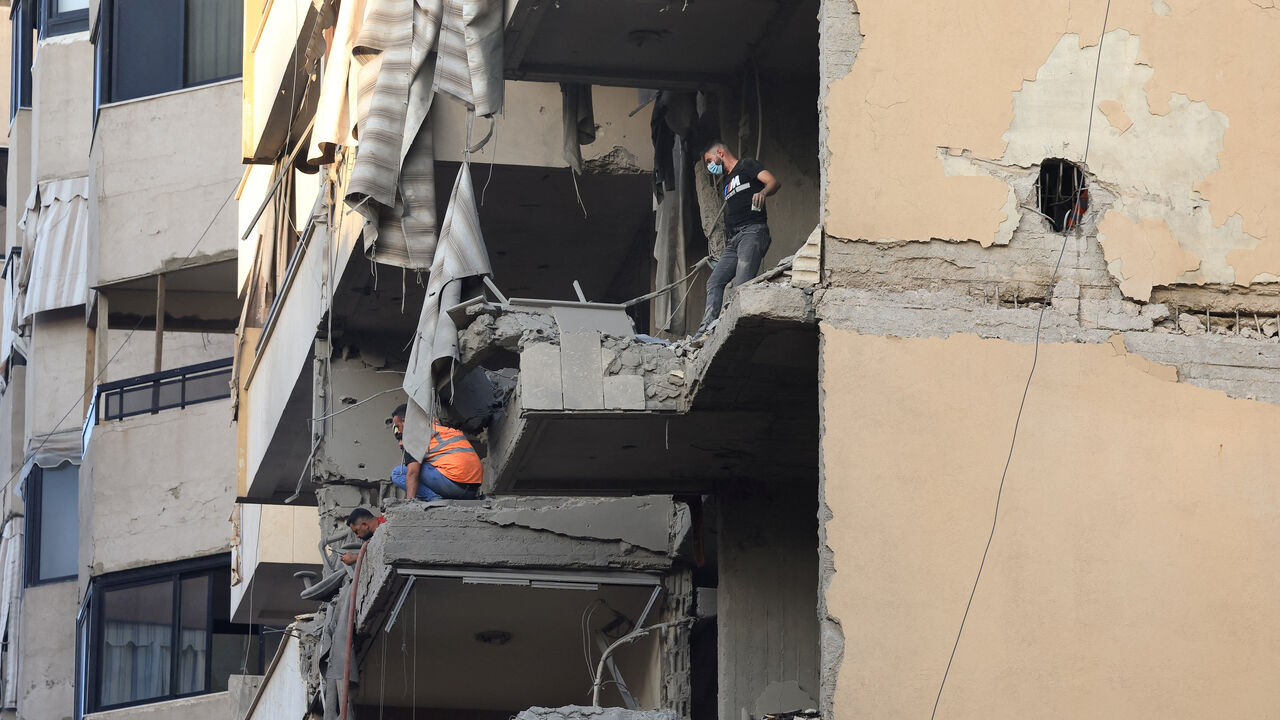 People inspect a damaged building, after Israeli military said on Sunday that it struck a militant from the Lebanese Iran-aligned Hezbollah group, in Beirut's southern suburbs, Lebanon November 23, 2025. REUTERS/Mohamed Azakir
