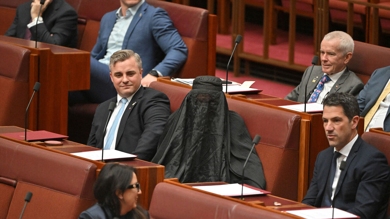 Senators react as One Nation leader Pauline Hanson wears a burqa in the Senate chamber at Parliament House in Canberra, Australia, November 24, 2025. AAP/Mick Tsikas via REUTERS    ATTENTION EDITORS - THIS IMAGE WAS PROVIDED BY A THIRD PARTY. NO RESALES. NO ARCHIVE. AUSTRALIA OUT. NEW ZEALAND OUT. NO COMMERCIAL OR EDITORIAL SALES IN NEW ZEALAND. NO COMMERCIAL OR EDITORIAL SALES IN AUSTRALIA.